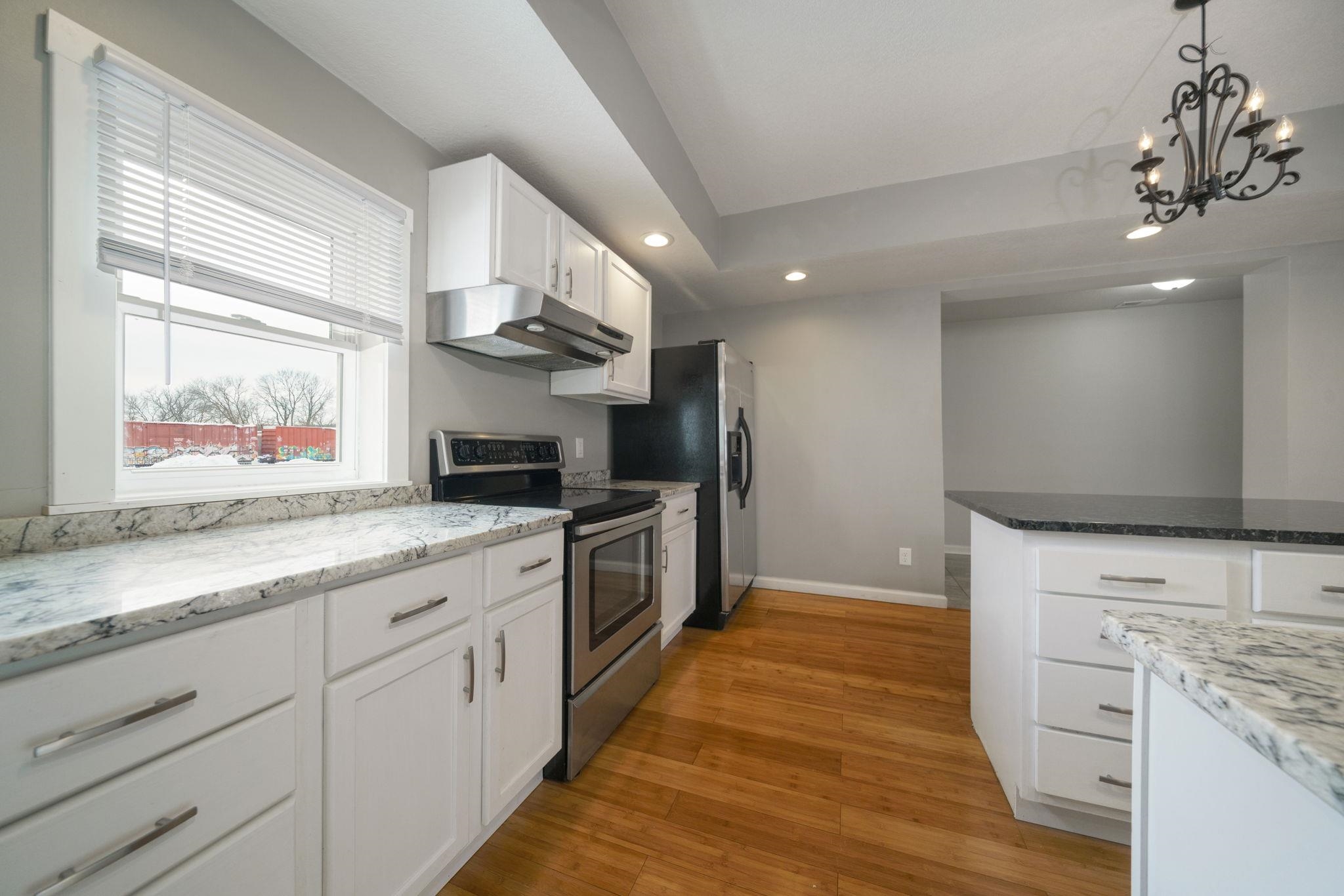 1104 South 4th Street Oregon, IL 61061 - Photo 2 of 36 a large kitchen with stainless steel appliances kitchen island granite countertop a stove and a view of living room
