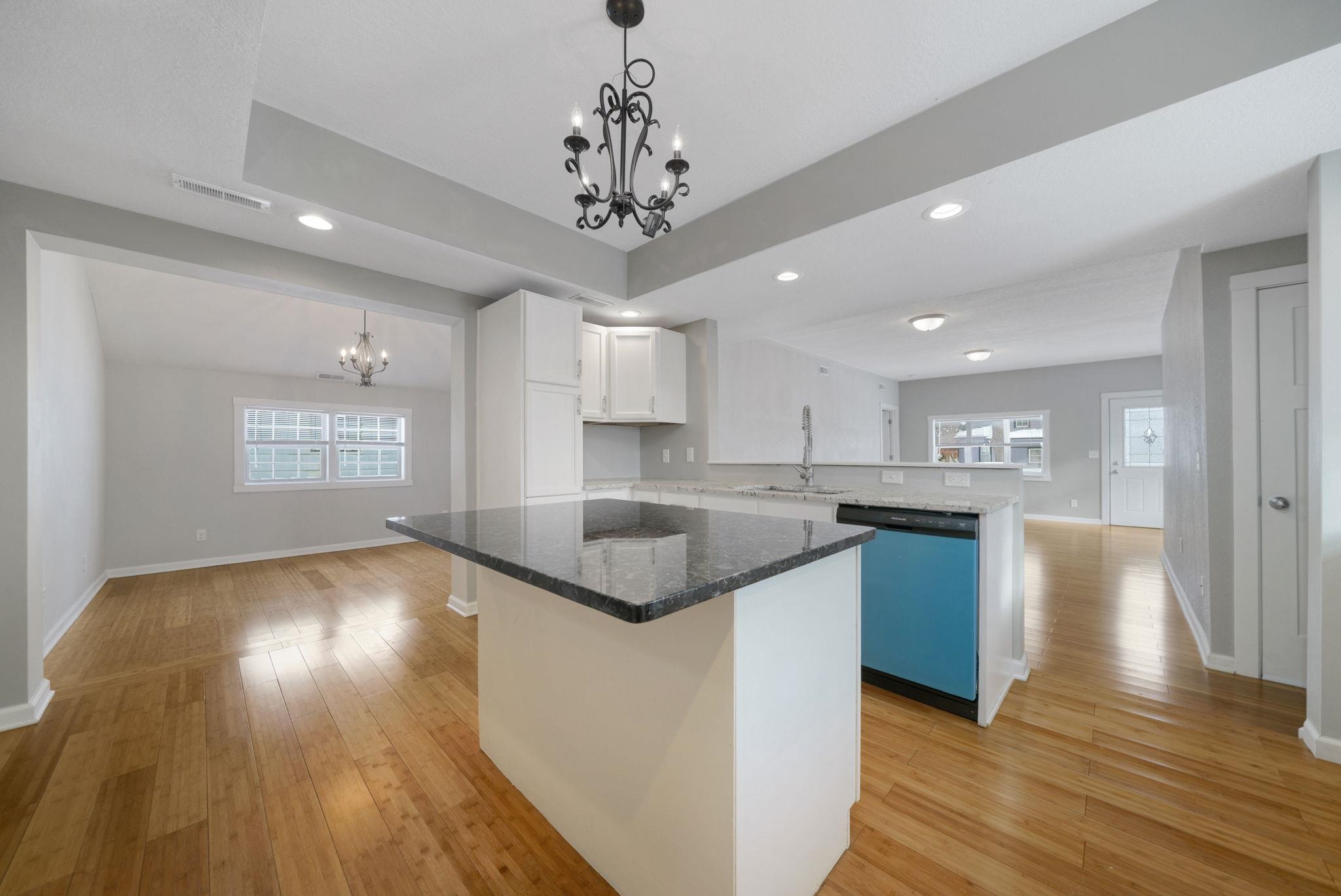 1104 South 4th Street Oregon, IL 61061 - Photo 3 of 36 a kitchen with stainless steel appliances granite countertop a sink a microwave oven a refrigerator and white cabinets with wooden floor