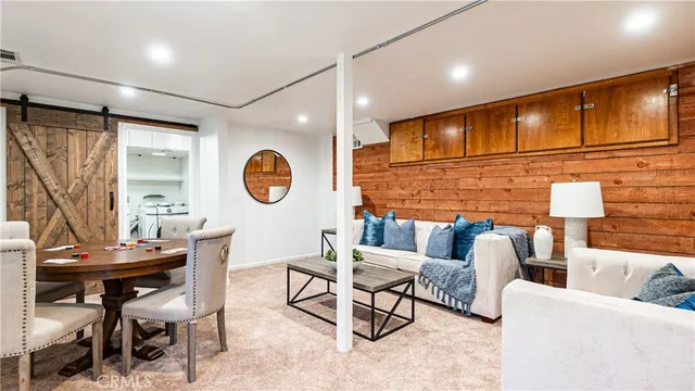 a living room with couches a dining table and kitchen view with wooden floor