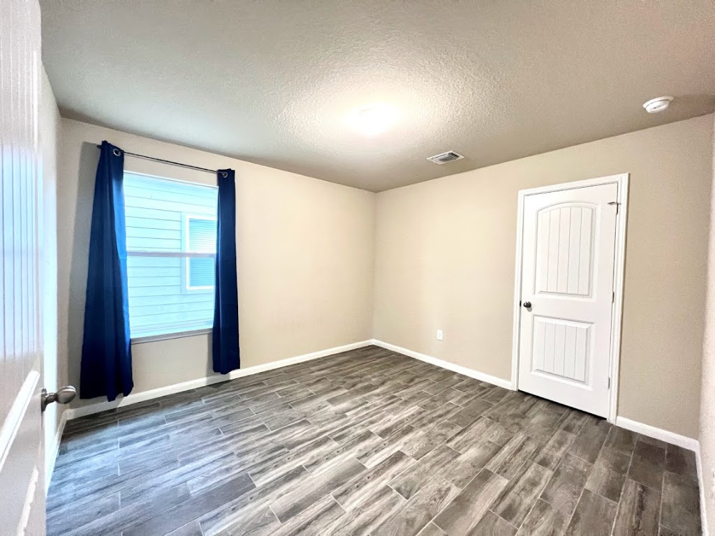 3208 Tilmon Ln. Austin, TX 78725 - Photo 14 of 21 an empty room with wooden floor and windows