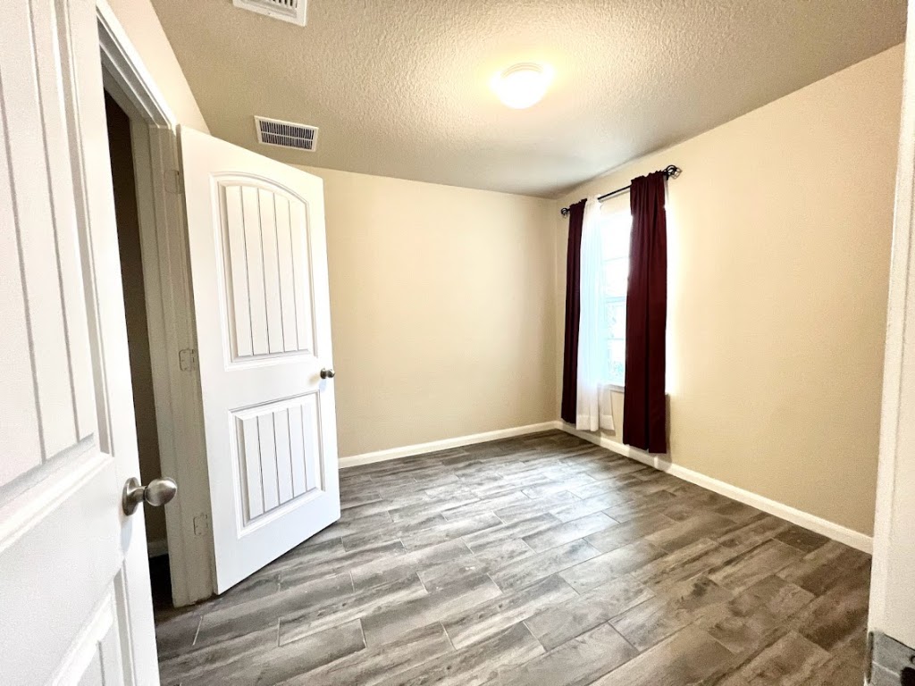 3208 Tilmon Ln. Austin, TX 78725 - Photo 15 of 21 an empty room with wooden floor and windows