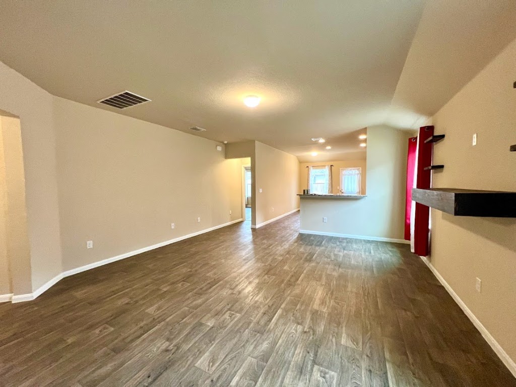 3208 Tilmon Ln. Austin, TX 78725 - Photo 3 of 21 an empty room with wooden floor and windows