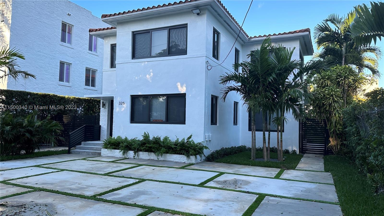 a front view of a house with a garden