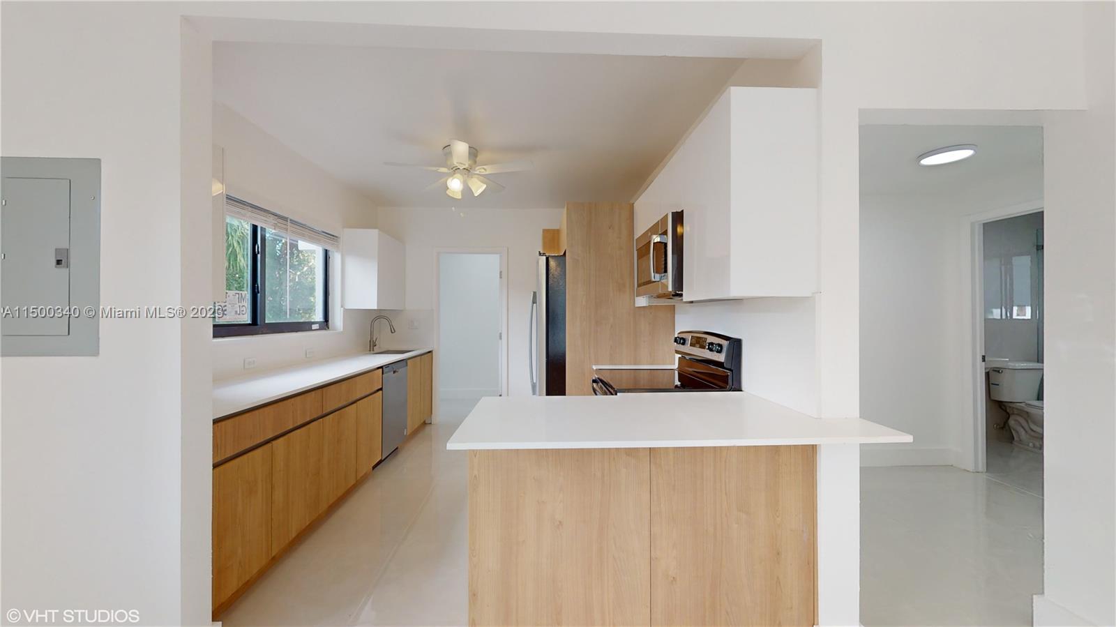 325 Southwest 30th Road, Unit L Miami, FL 33129 - Photo 5 of 25 a large kitchen with a sink and stainless steel appliances