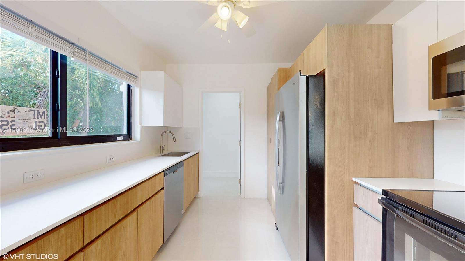 325 Southwest 30th Road, Unit L Miami, FL 33129 - Photo 6 of 25 a kitchen with stainless steel appliances a sink and a refrigerator
