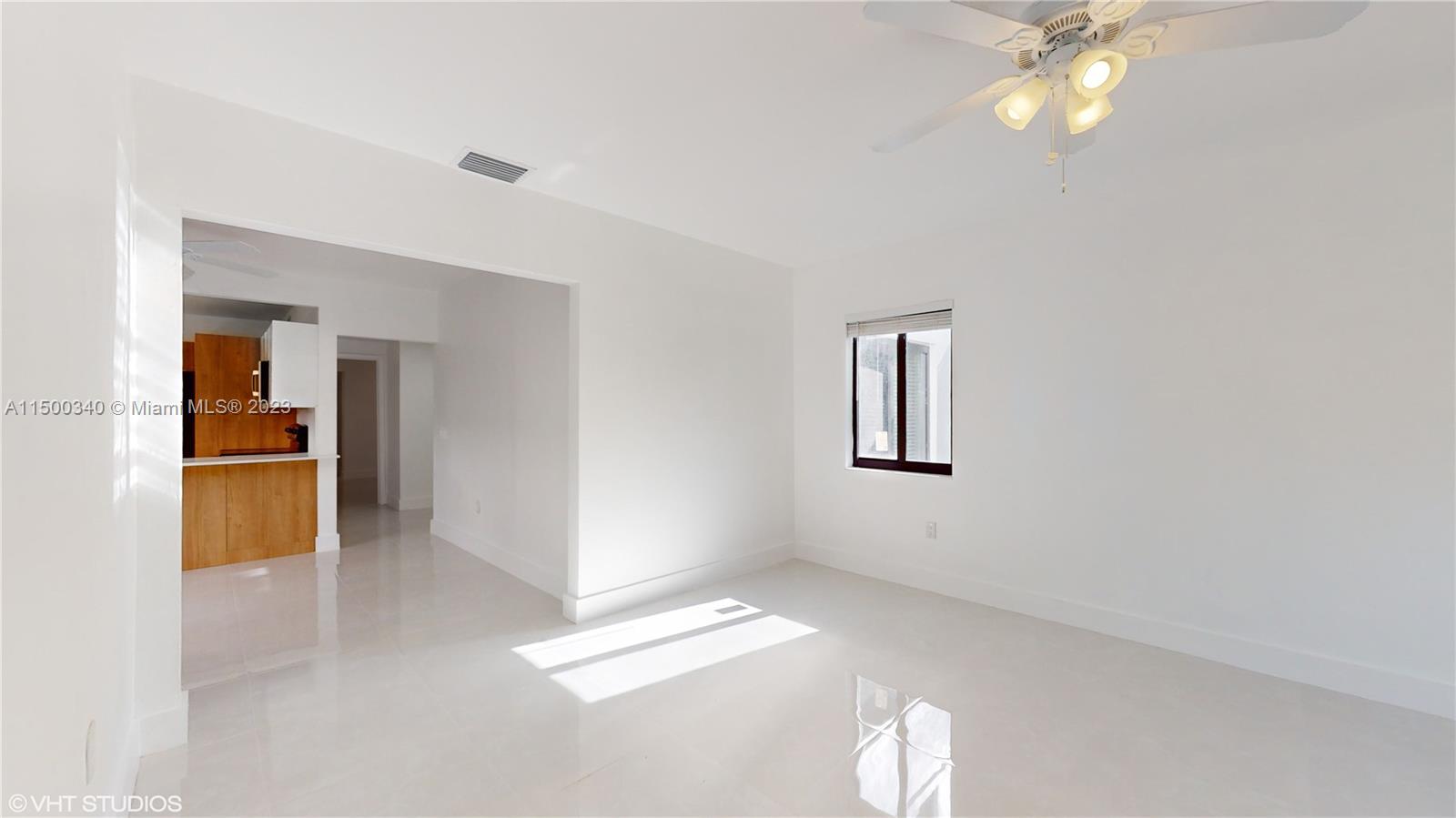 325 Southwest 30th Road, Unit L Miami, FL 33129 - Photo 9 of 25 a view of empty room with wooden floor and kitchen view