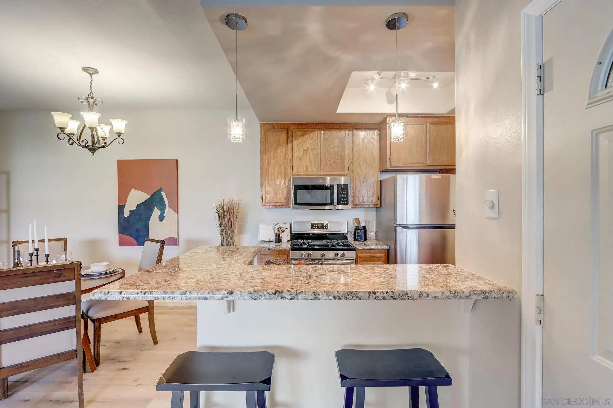 13832 Midland Road Poway, CA 92064 - Photo 12 of 36 a kitchen with a refrigerator a stove a sink dishwasher a dining table and chairs with wooden floor