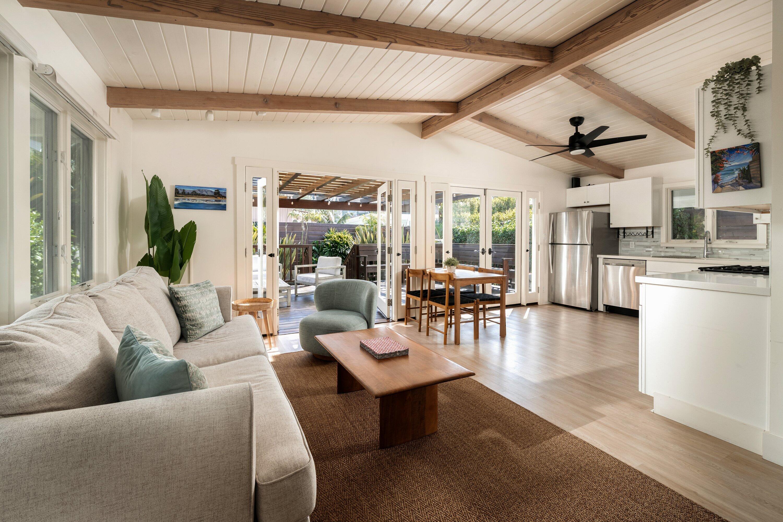 a living room with furniture kitchen view and a large window