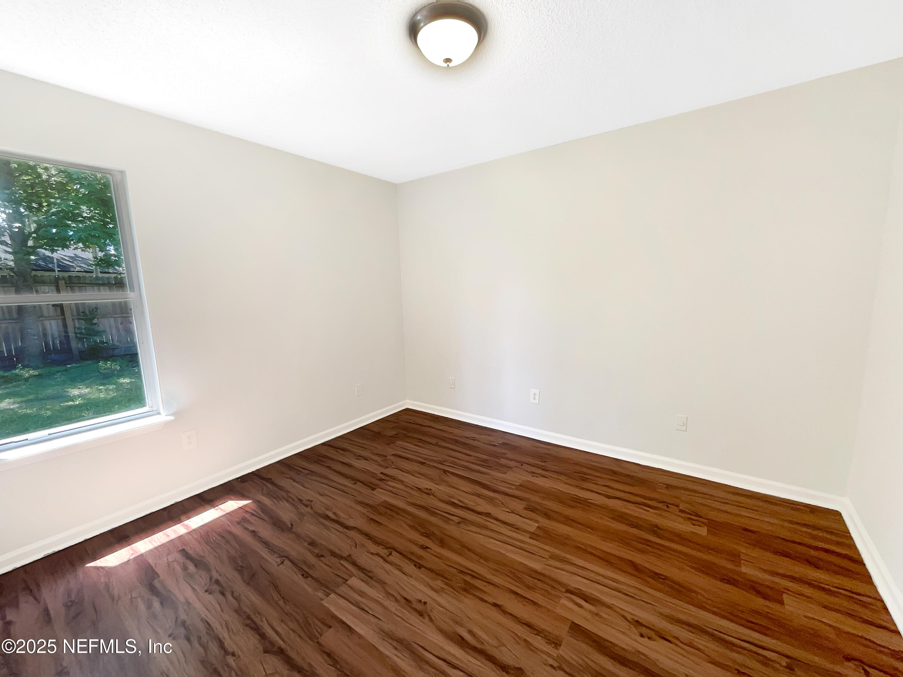 2058 Manucy Court Middleburg, FL 32068 - Photo 13 of 18 a view of an empty room with wooden floor and a window