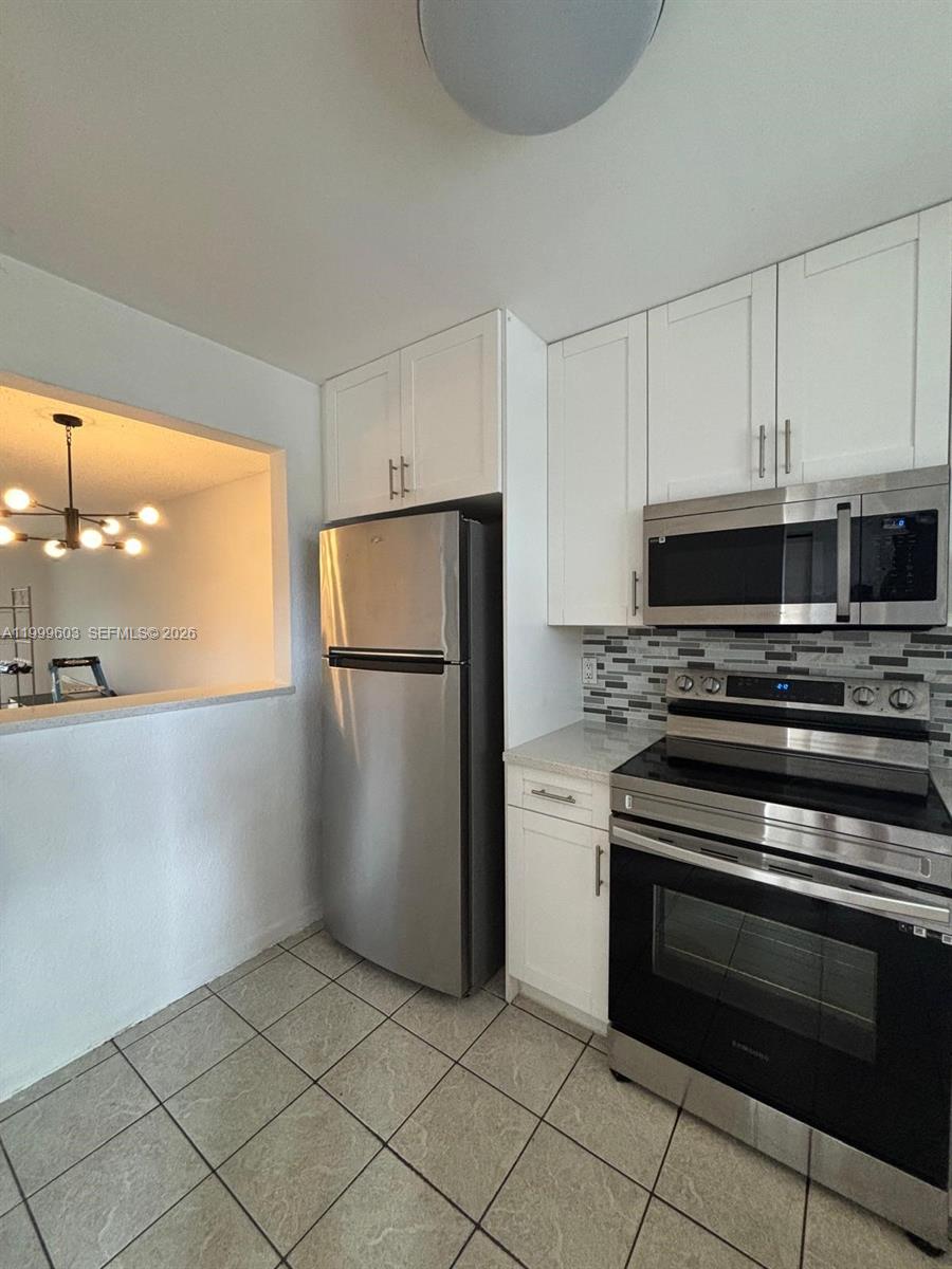 21904 Lake Forest Circle, Unit 203 Boca Raton, FL 33433 - Photo 2 of 11 a kitchen with cabinets and steel stainless steel appliances