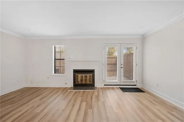 an empty room with windows and fireplace