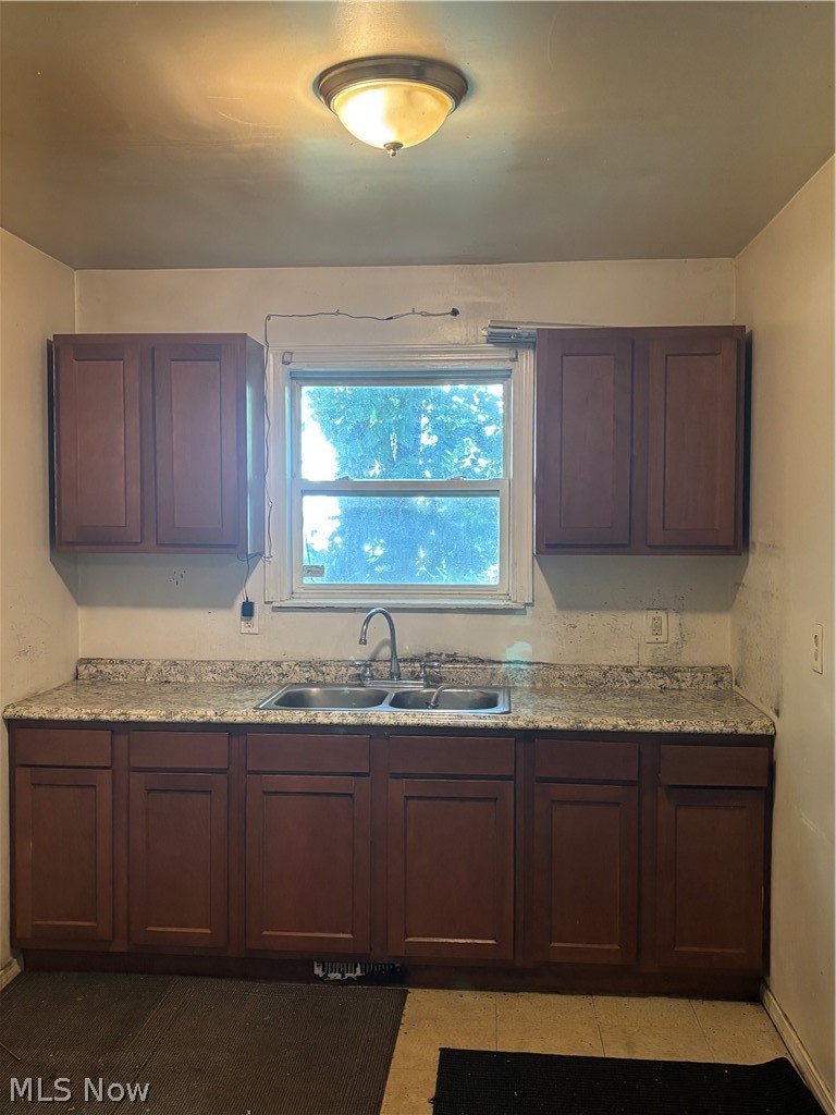 10014 Reno Avenue Cleveland, OH 44105 - Photo 4 of 11 Kitchen featuring sink, light tile patterned flooring, and light stone countertops