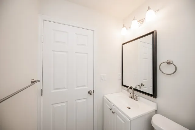 a bathroom with a toilet sink and mirror