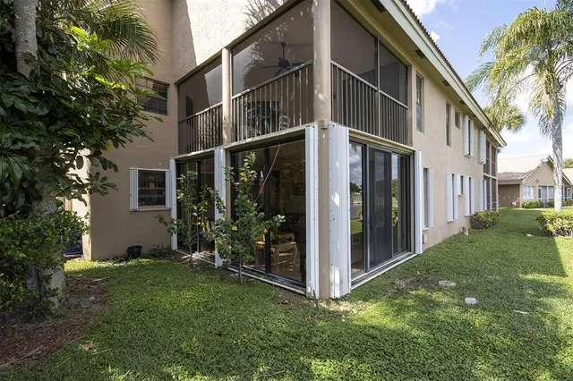a view of a house with brick walls and a yard with plants