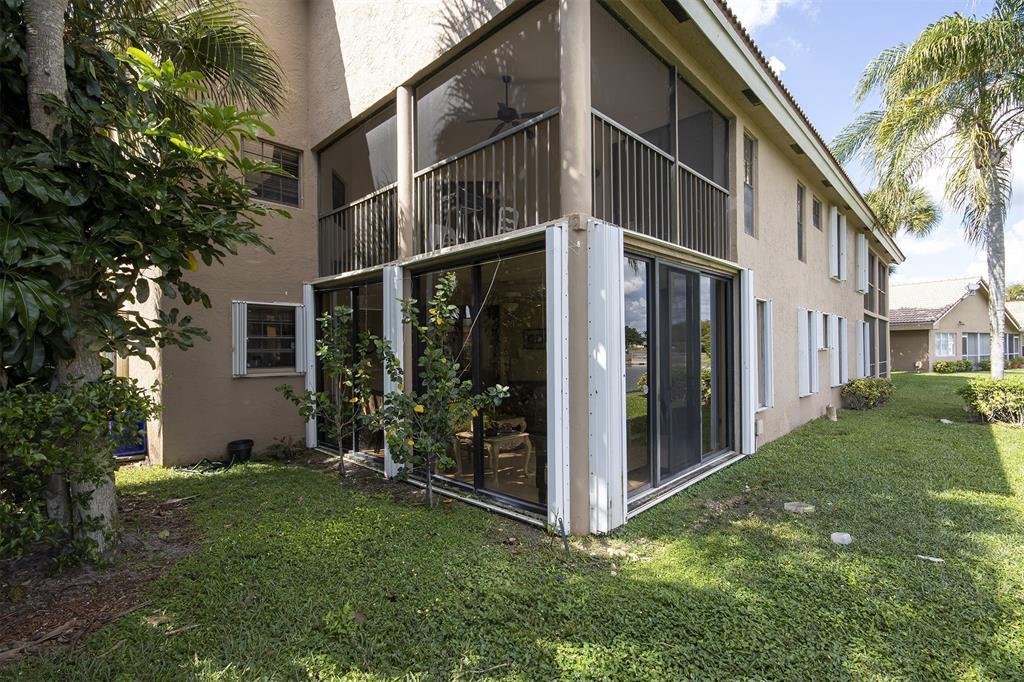 18258 Covina Way, Unit 102 Boca Raton, FL 33498 - Photo 12 of 26 a view of a house with brick walls and a yard with plants