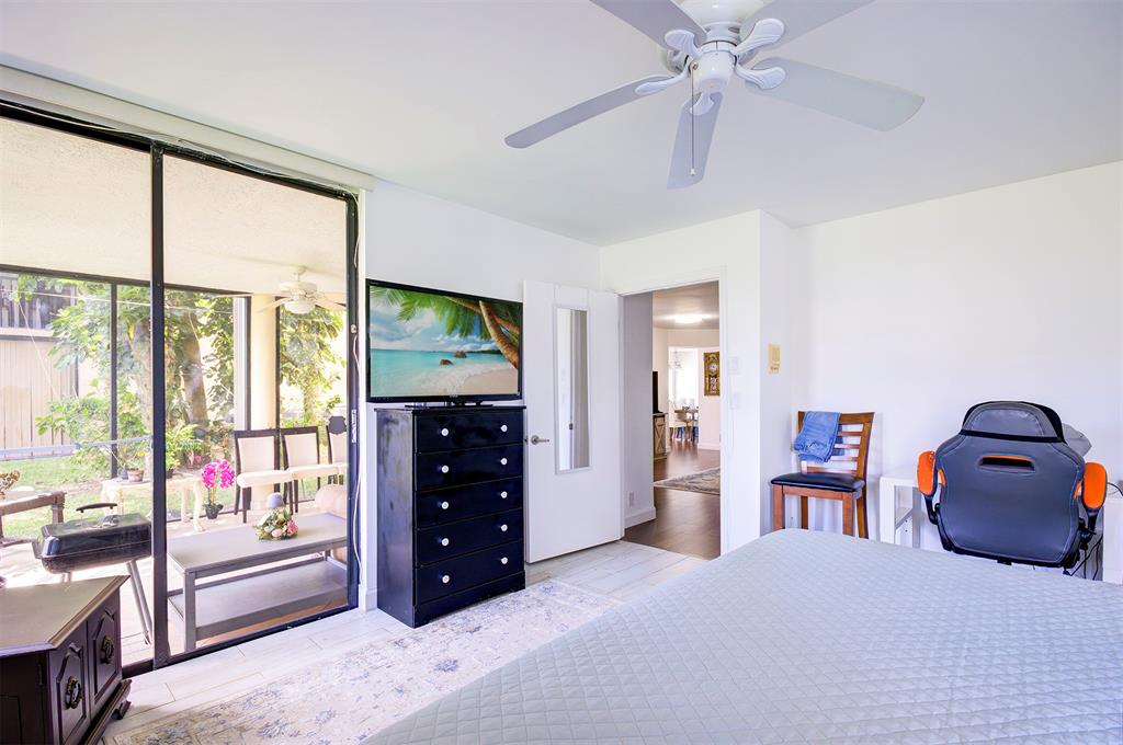 18258 Covina Way, Unit 102 Boca Raton, FL 33498 - Photo 13 of 26 a bedroom with a bed and large windows