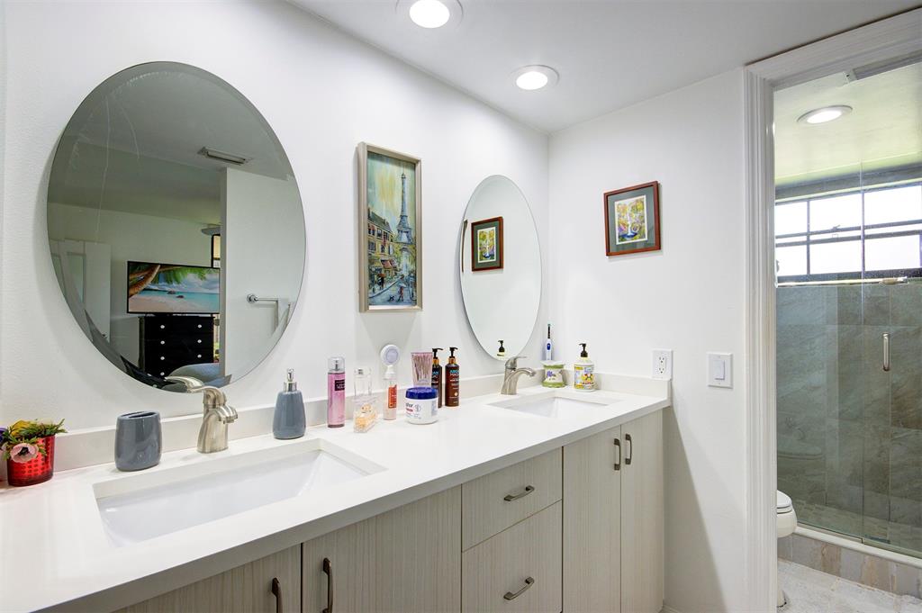 18258 Covina Way, Unit 102 Boca Raton, FL 33498 - Photo 15 of 26 a bathroom with a double vanity sink and a mirror