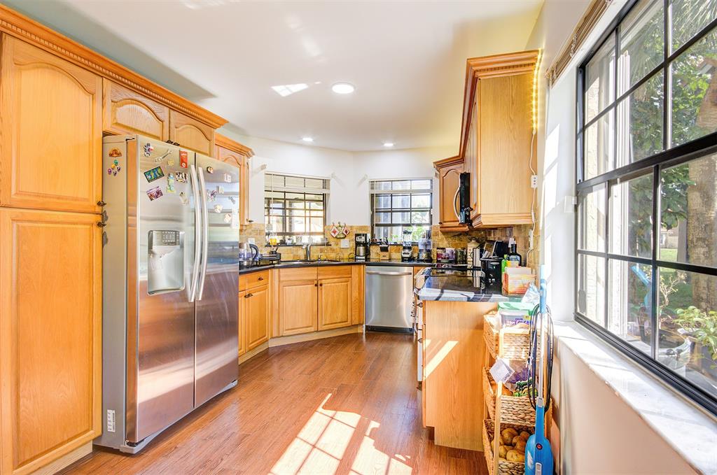 18258 Covina Way, Unit 102 Boca Raton, FL 33498 - Photo 6 of 26 a kitchen with stainless steel appliances a refrigerator a sink a stove and white cabinets with wooden floor