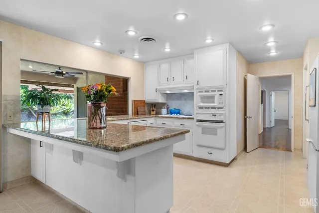 a dining room with furniture a chandelier and wooden floor