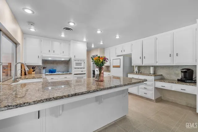a kitchen with a dining table chairs and white cabinets