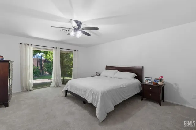 a bedroom with furniture a ceiling fan and a rug