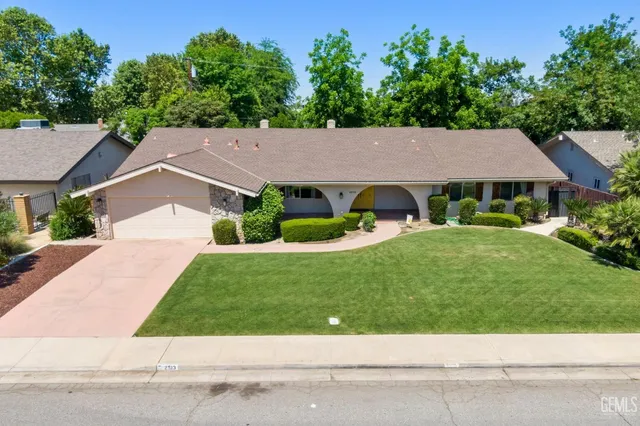a house with green field in front of it