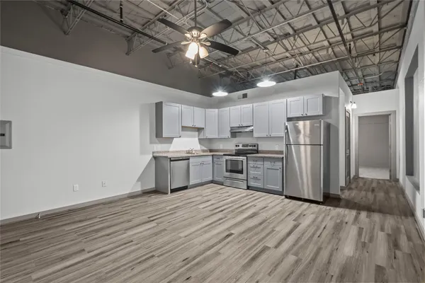 a kitchen with stainless steel appliances granite countertop a sink refrigerator and cabinets
