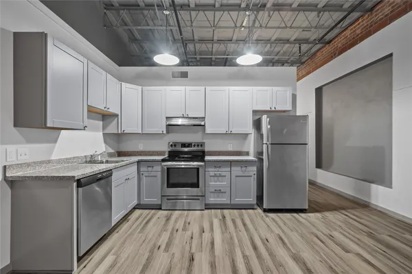 a kitchen with a sink a refrigerator and cabinets