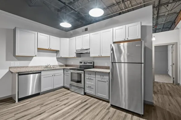 a kitchen with granite countertop a refrigerator stove top oven and sink