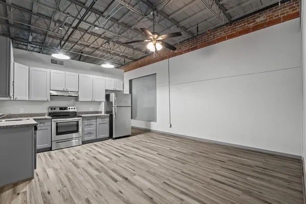 a kitchen with stainless steel appliances granite countertop a refrigerator and a stove top oven
