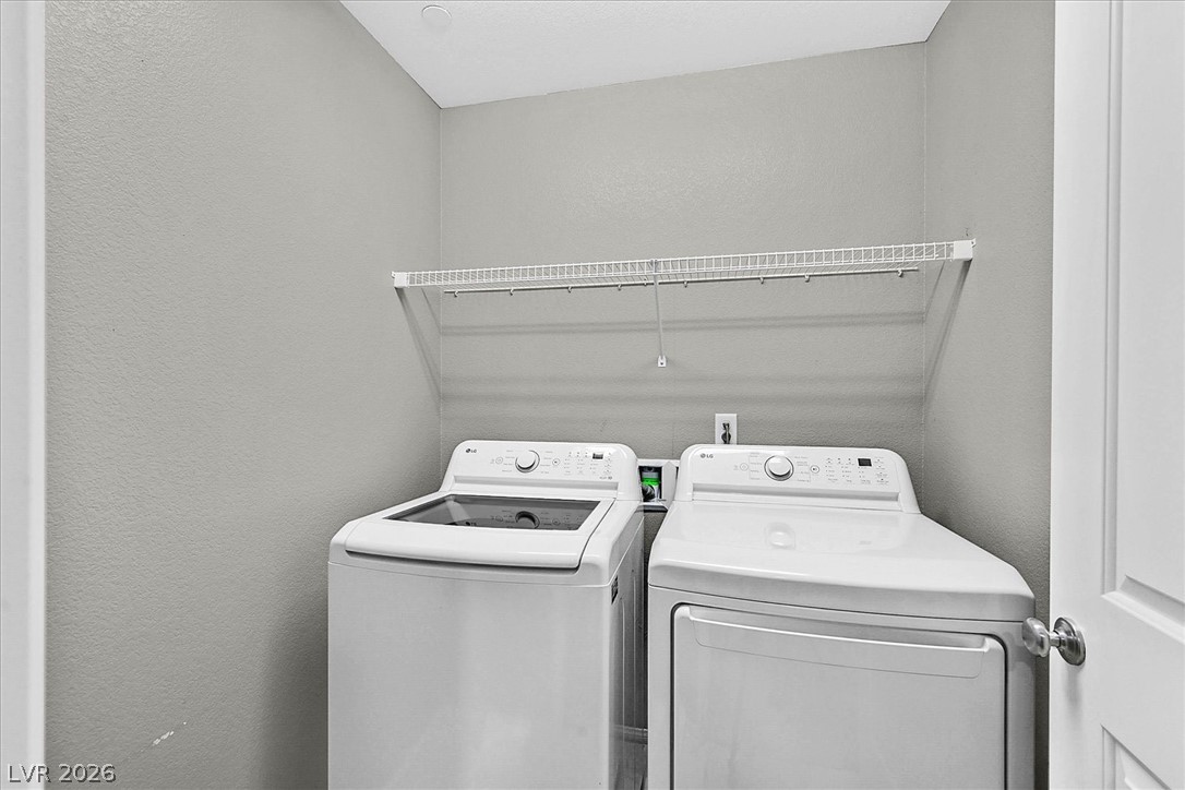 2823 Turnstone Ridge Street Henderson, NV 89044 - Photo 22 of 25 Functional laundry space featuring modern appliances and convenient overhead shelving.