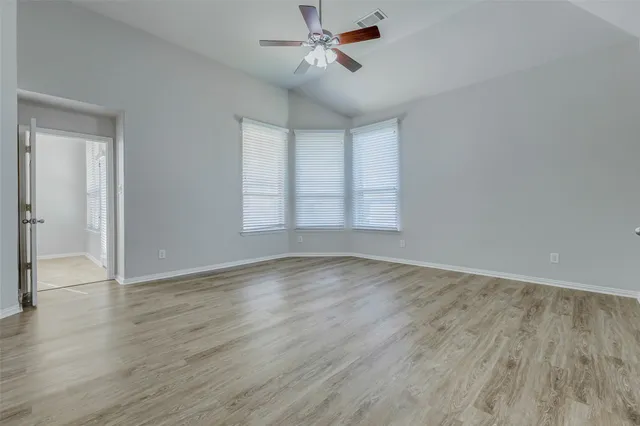 a view of a hallway with wooden floor and chandelier
