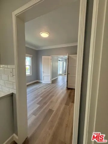 a view of a hallway with wooden floor and staircase