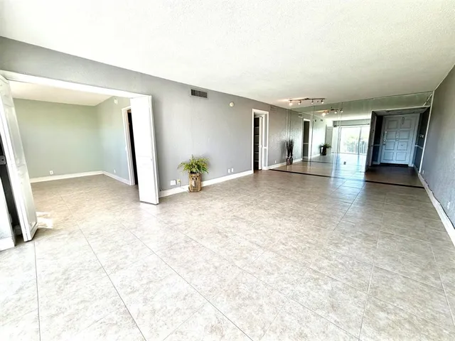 a view of a livingroom with wooden floor and kitchen space