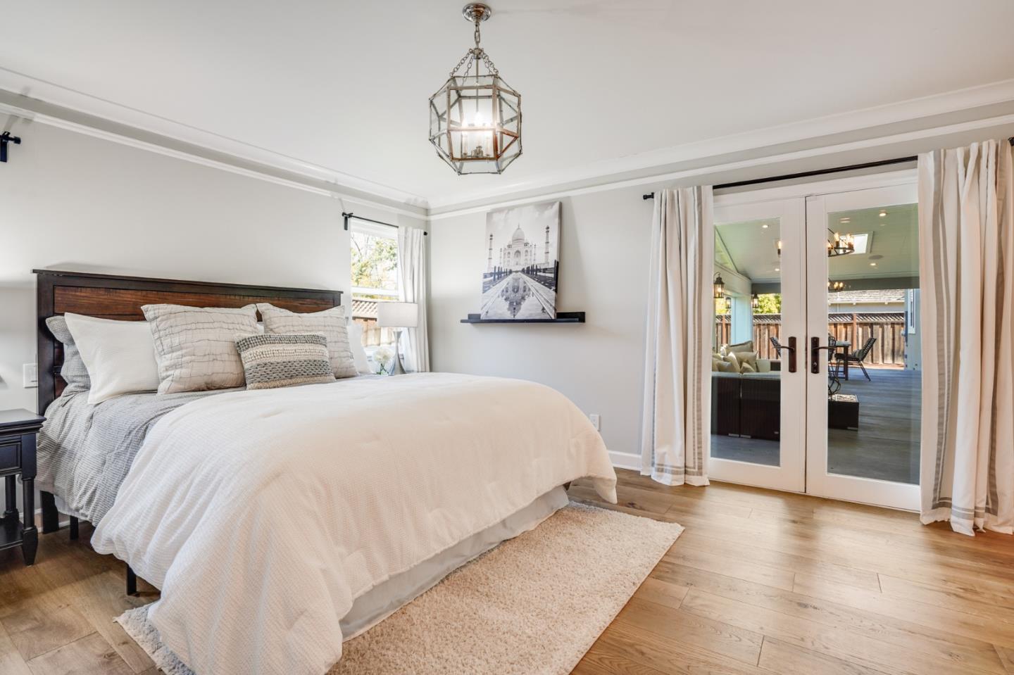 1564 Meadow Lane Mountain View, CA 94040 - Photo 17 of 36 a spacious bedroom with a bed and a chandelier