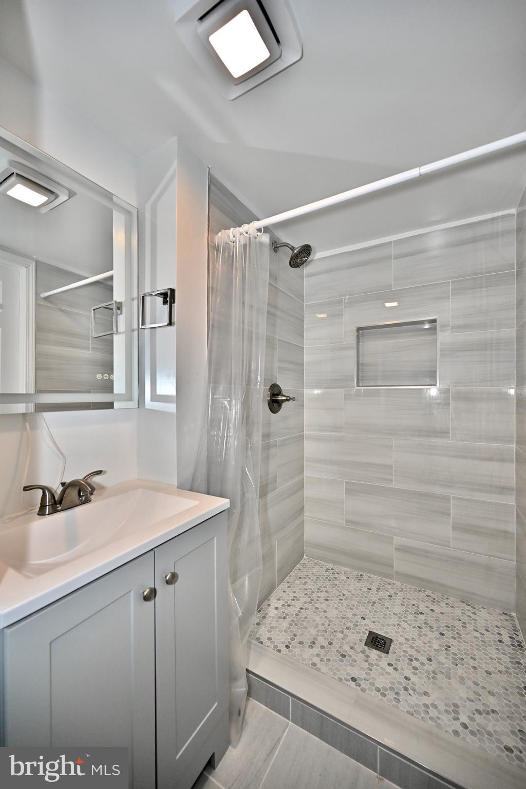 6308 Marywood Road Bethesda, MD 20817 - Photo 30 of 30 a bathroom with a sink a shower and a mirror
