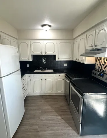 a kitchen with stainless steel appliances a refrigerator sink and cabinets