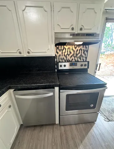 a view of granite countertop white cabinets and stainless steel appliances