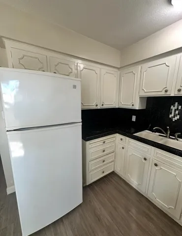 a kitchen with a refrigerator a sink and cabinets