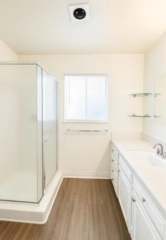 a view of a kitchen with white cabinets and wooden floor