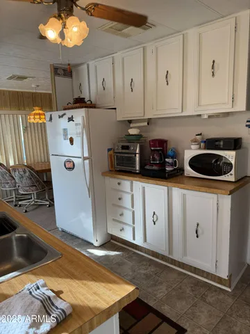 a kitchen with white cabinets and appliances