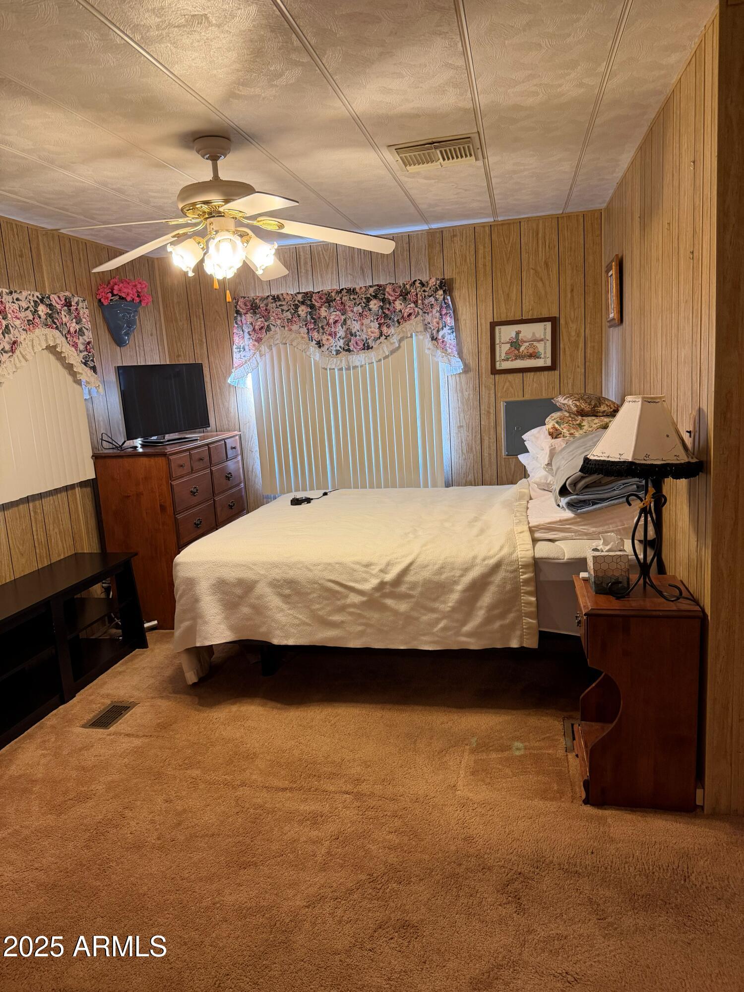 939 North Acacia Road, Unit 25 Apache Junction, AZ 85119 - Photo 16 of 25 a bedroom with a bed and a chandelier