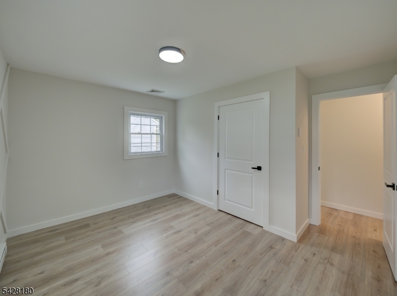 13 Fillmore Street Washington, NJ 07882 - Photo 12 of 21 a view of an empty room with wooden floor and window