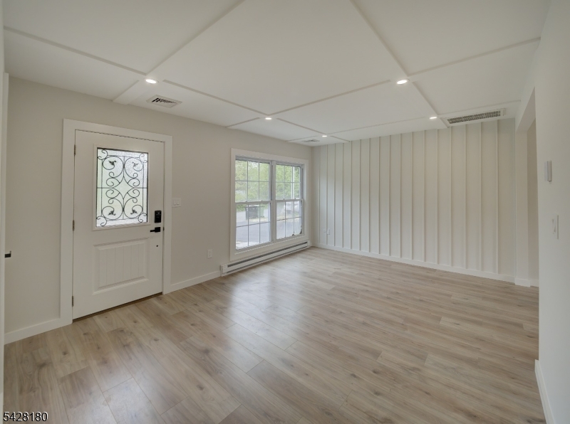 13 Fillmore Street Washington, NJ 07882 - Photo 2 of 21 an empty room with wooden floor and windows