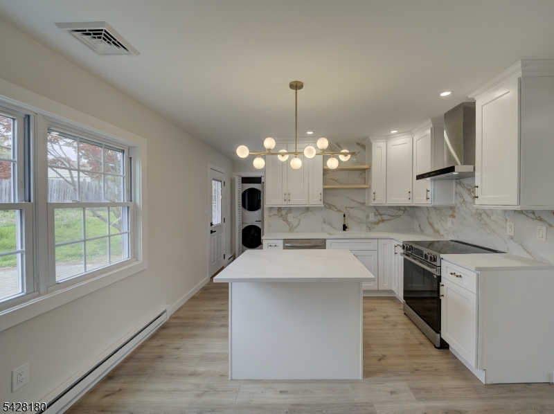 13 Fillmore Street Washington, NJ 07882 - Photo 7 of 21 a large kitchen with kitchen island a stove a sink dishwasher a oven a dining table and chairs with wooden floor