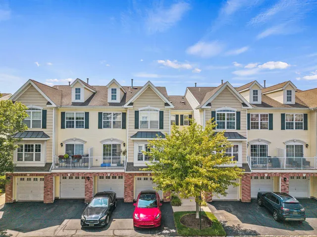 a view of a white house with a fountain and a potted plant