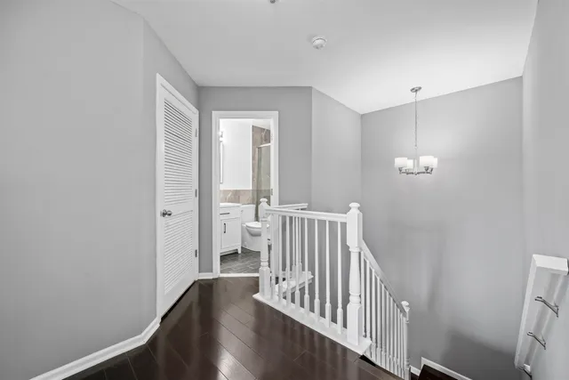 a view of a hallway with wooden floor and windows