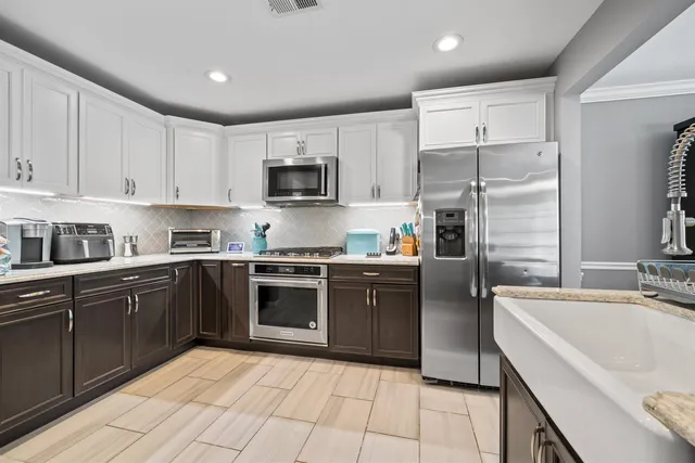 a open kitchen with stainless steel appliances granite countertop a refrigerator sink and cabinets
