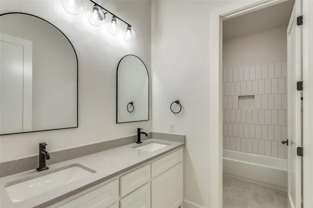 a bathroom with a sink and mirror with bathtub