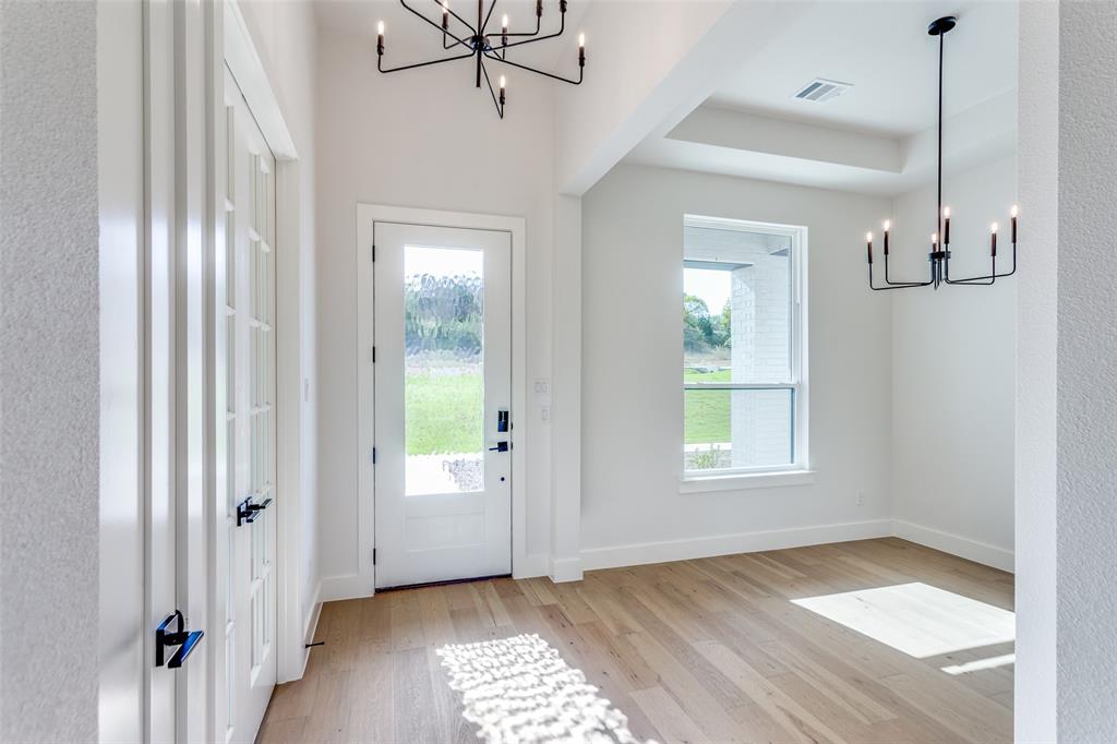 505 Aermotor Loop Weatherford, TX 76085 - Photo 3 of 17 a view of an empty room with a window and wooden floor